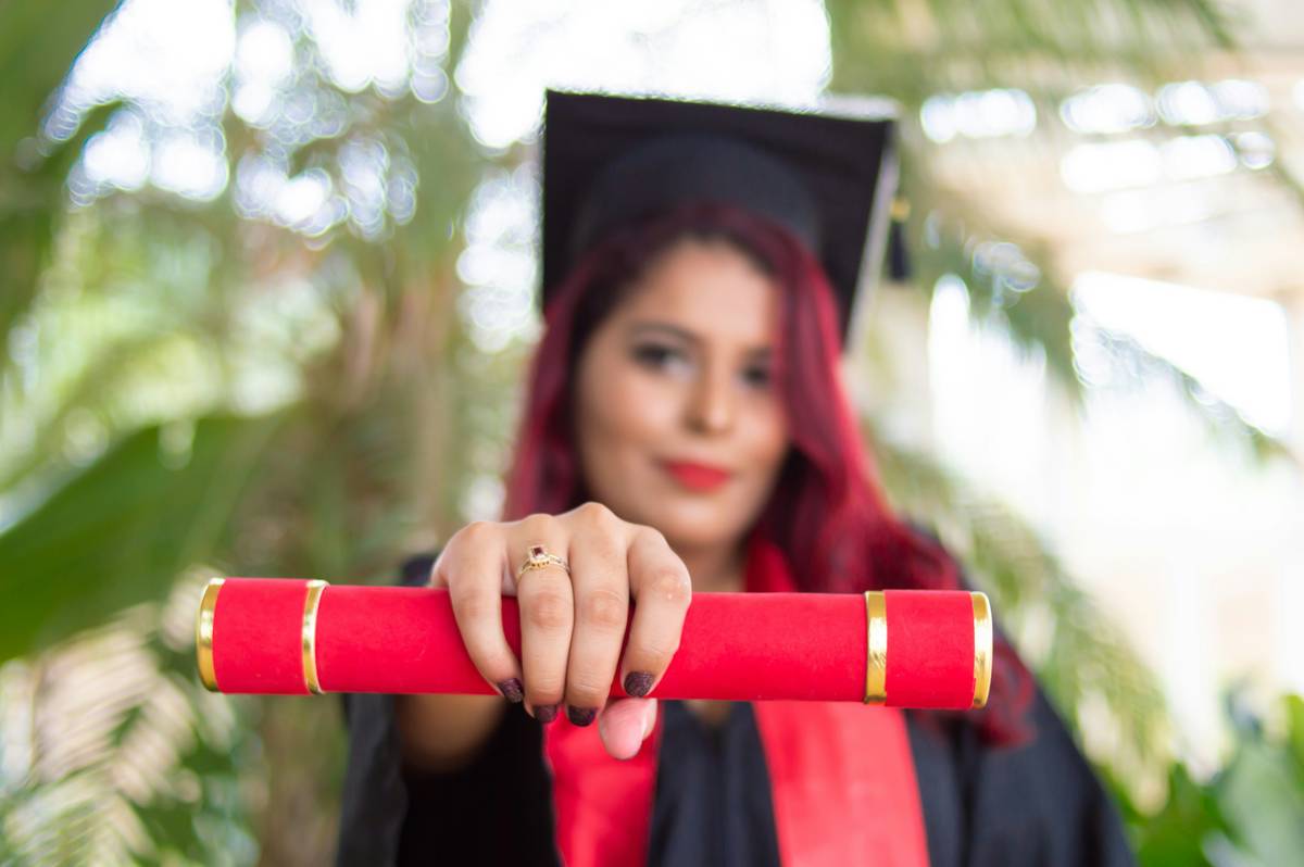 A styled graduation table setting with graduation decorations red and black theme, featuring balloons, banners, and photo booth props
